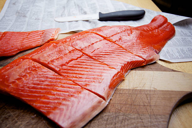 Wild Caught Salmon raw fillet on cutting board Wild Sockeye Salmon fillet on cutting board sockeye salmon filet stock pictures, royalty-free photos & images
