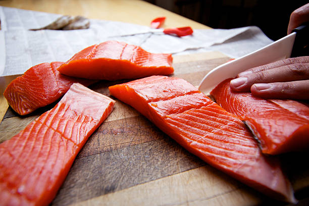 Wild Salmon raw fillet on cutting board Wild Sockeye Salmon fillet on cutting board sockeye salmon filet stock pictures, royalty-free photos & images
