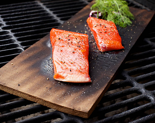 Wild Salmon fillet outdoor cedar plank bbq grill Wild Salmon fillet cedar plank outdoor bbq grill sockeye salmon filet stock pictures, royalty-free photos & images