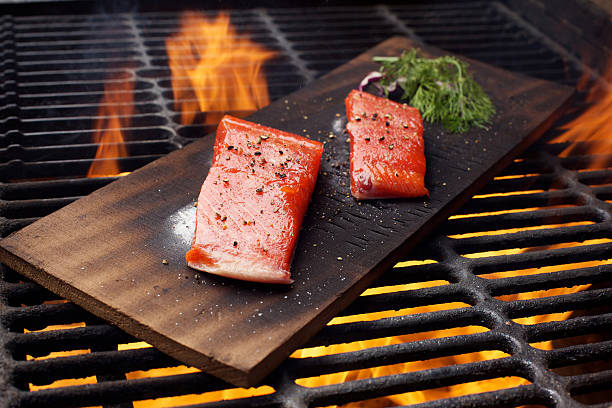 Wild Salmon fillet outdoor cedar plank bbq grill Wild Salmon fillet cedar plank outdoor bbq grill sockeye salmon filet stock pictures, royalty-free photos & images