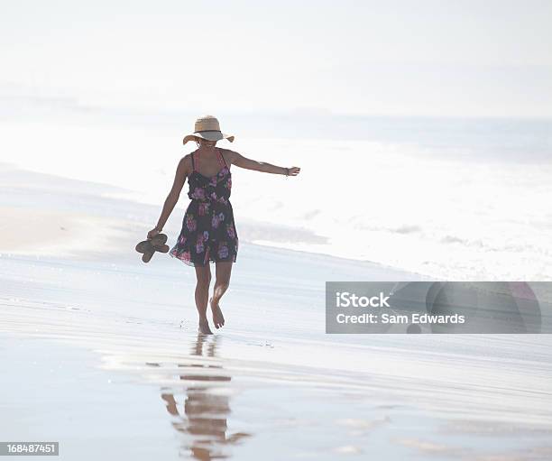 Kobieta Przewożących Sandały Na Plaży - zdjęcia stockowe i więcej obrazów 20-24 lata - 20-24 lata, Beztroski, Codzienne ubranie