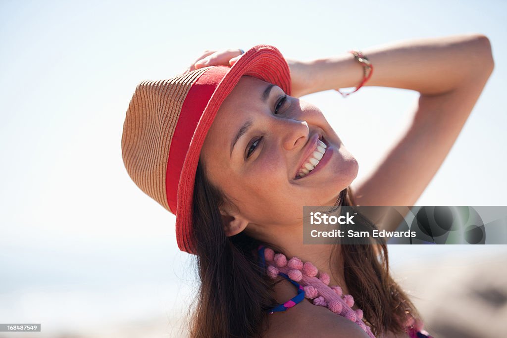 Mulher sorridente com chapéu de sol na praia - Foto de stock de 30 Anos royalty-free