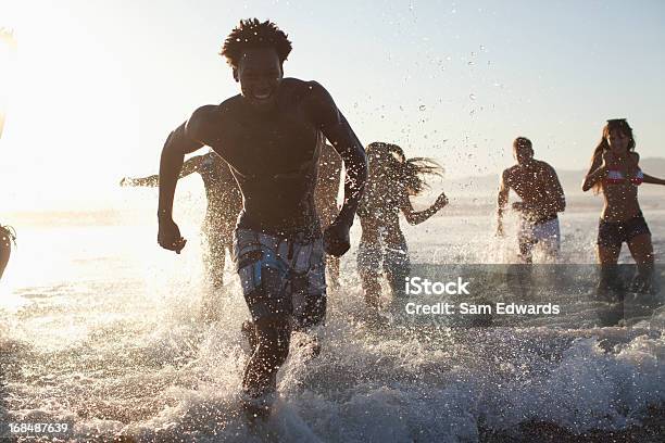 Foto de Amigos Jogando Em Ondas Na Praia e mais fotos de stock de Esparramar líquido - Esparramar líquido, Férias, Praia