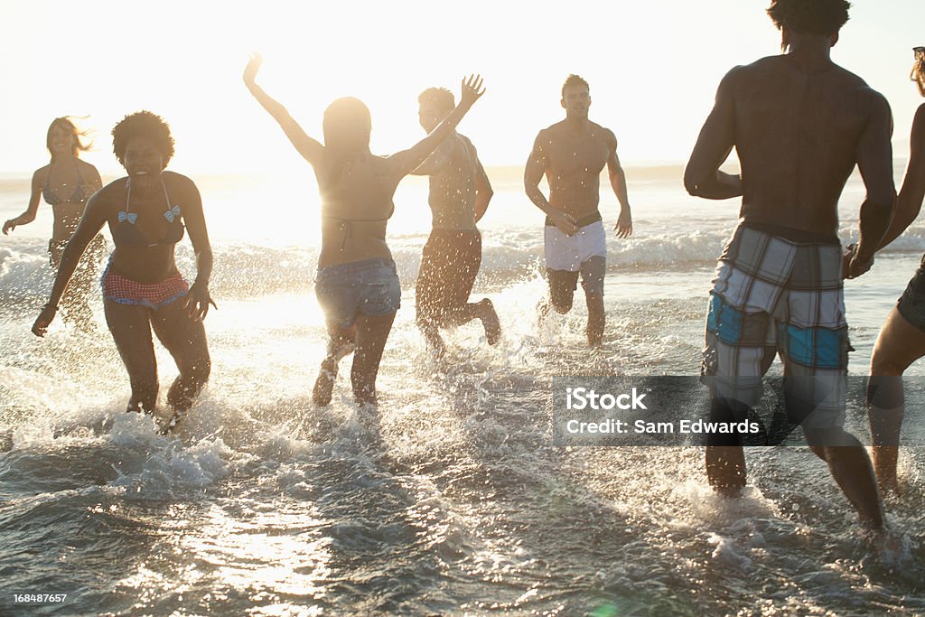 Amigos jogando em ondas na praia - Foto de stock de 20-24 Anos royalty-free