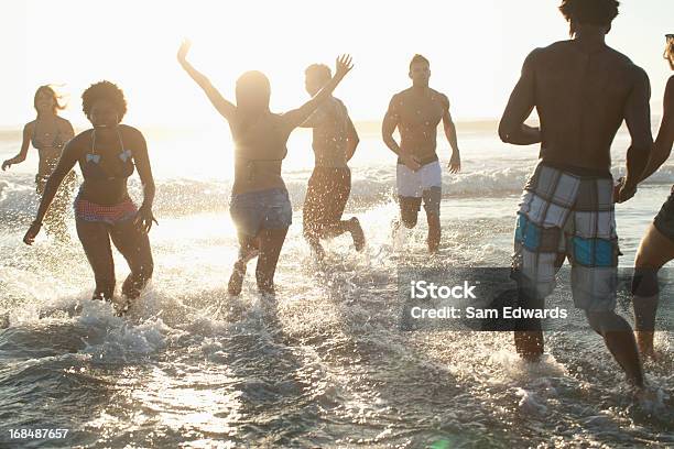 Foto de Amigos Jogando Em Ondas Na Praia e mais fotos de stock de 20-24 Anos - 20-24 Anos, 25-30 Anos, 30 Anos