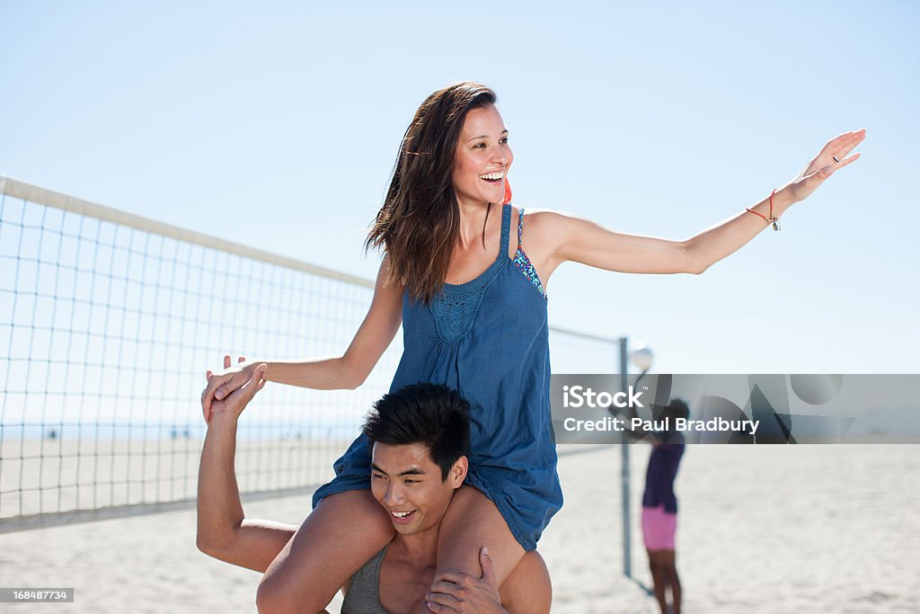 ガールフレンドと肩を運ぶ男 - スポーツ バレーボールのロイヤリティフリーストックフォト