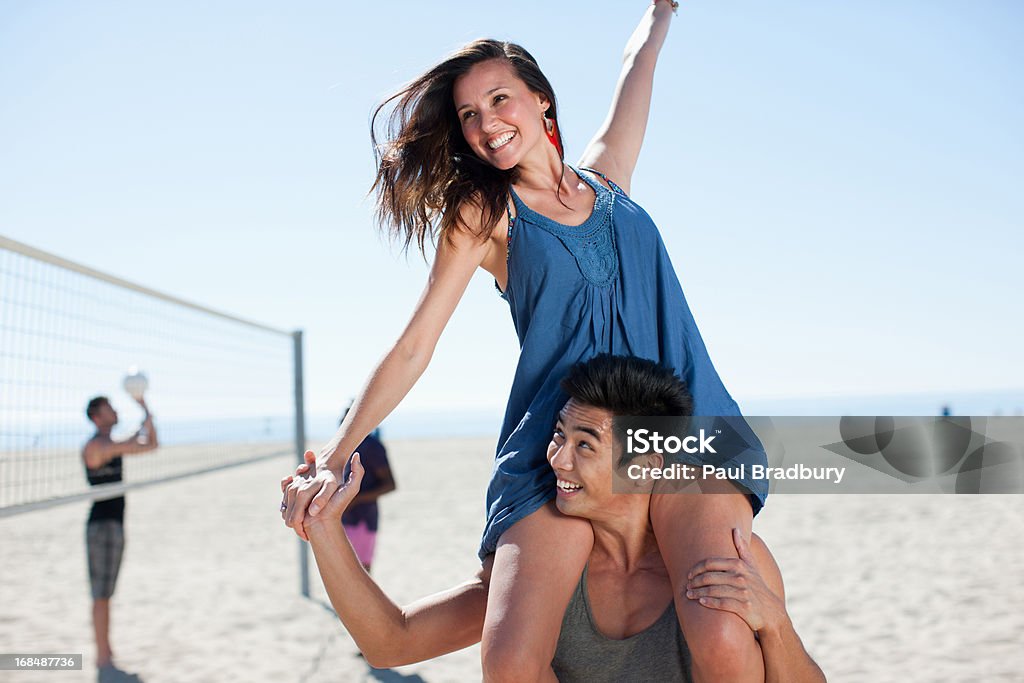 Uomo portare ragazza sulle spalle - Foto stock royalty-free di 20-24 anni