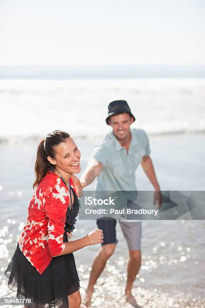 カップルのビーチで遊ぶウェイブズ - 25-29歳のストックフォトや画像を多数ご用意 - 25-29歳, 2人, 30-34歳