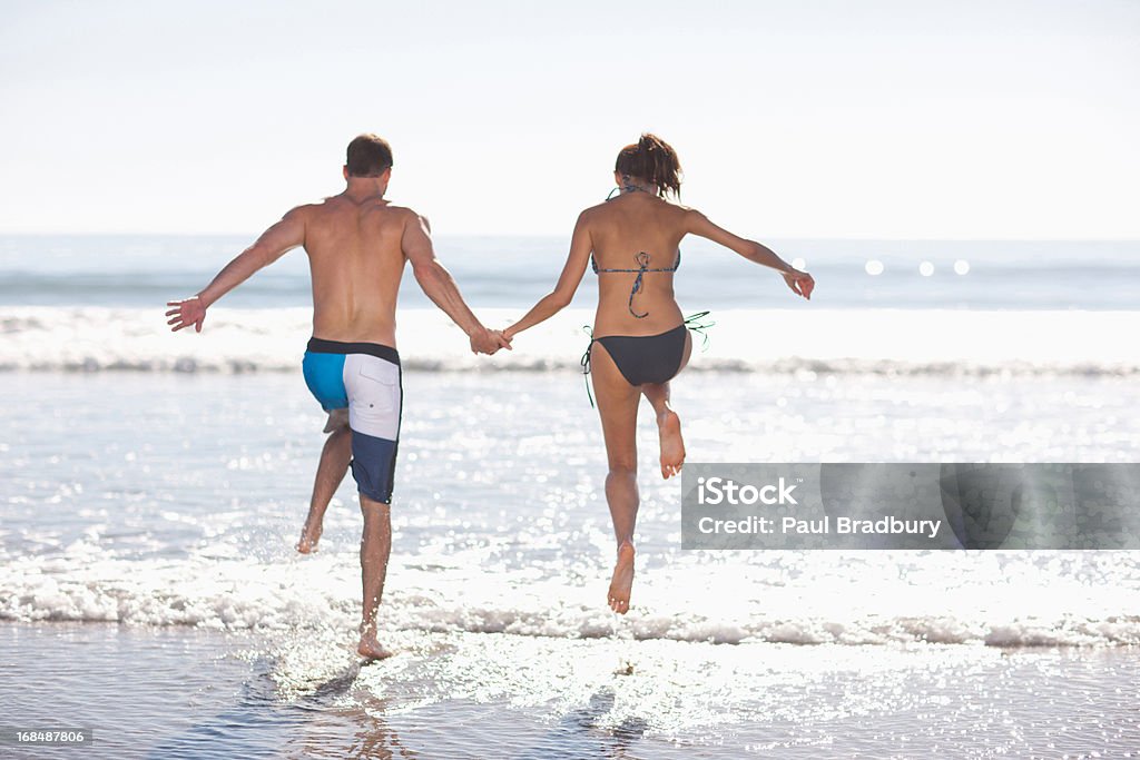 Casal brincando nas ondas na praia - Royalty-free Chapinhar Foto de stock