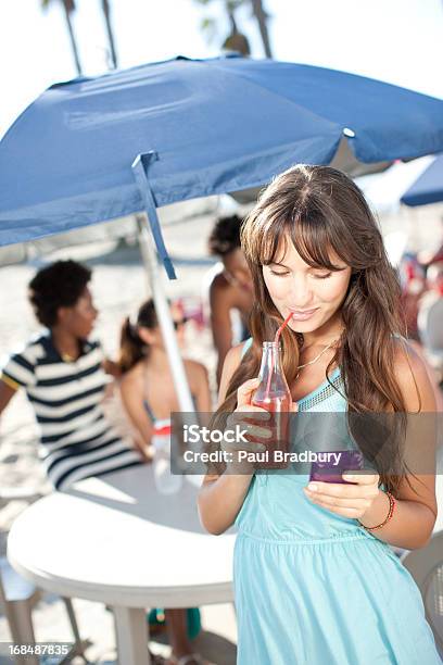 Mujer Con Jugo Mediante Teléfono Móvil Al Aire Libre Foto de stock y más banco de imágenes de 20-24 años