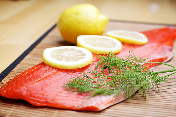 Wild Salmon raw fillet on bamboo Wild Sockeye Salmon fillet on bamboo with lemons and dill herb sockeye salmon filet stock pictures, royalty-free photos & images