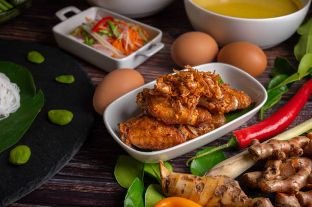 Deep fried chicken and fried onions, southern style herbs recipe, eaten with rice noodles and pickled vegetables.