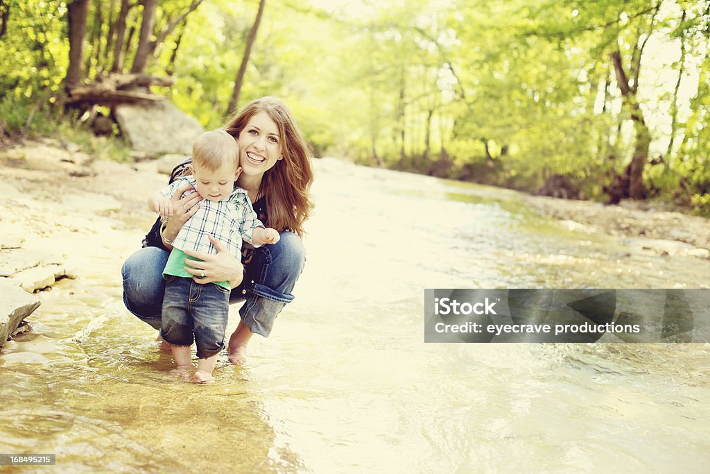 Madre y niño pequeño niño al aire libre river adventure - Foto de stock de Adulto joven libre de derechos