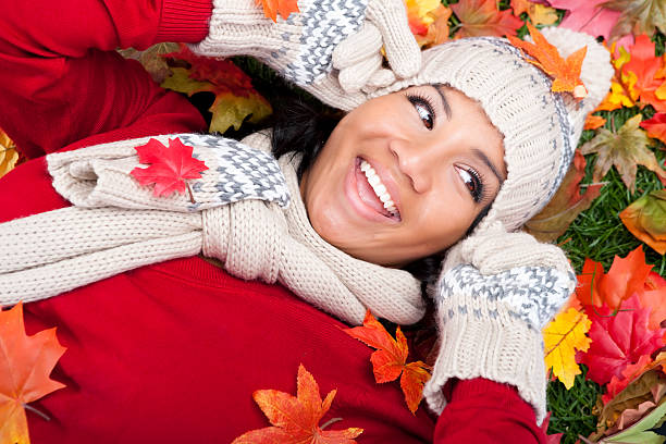 souriant femme jeter les feuilles d'automne - pulling a name from a hat photos et images de collection