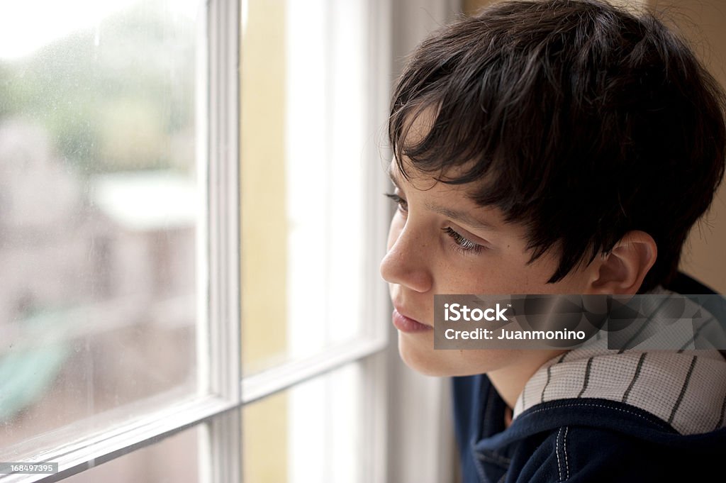 Pensativo criança olhando através de uma janela - Foto de stock de Criança royalty-free