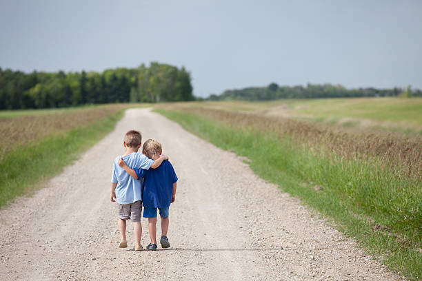 Two Cute Preschool Boys Walking Down the Road stock photo