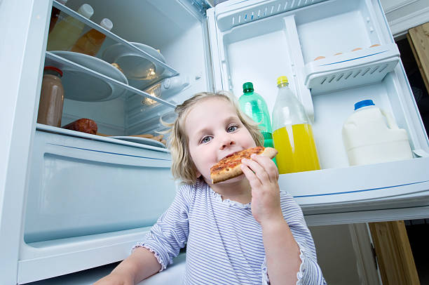 istock Young Girl Eating Cold Pizza From The Fridge 168503204