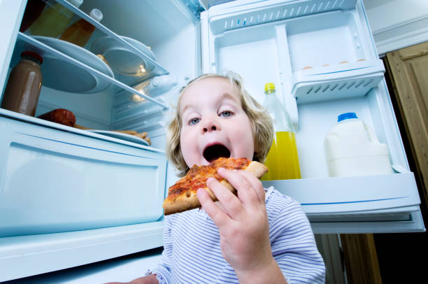 istock Young Girl Eating Cold Pizza From The Fridge 168504329