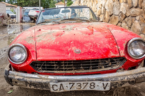 Villamanta, Madrid, Spain; 09-05-2023: Classic car Fiat 124 sport spider damaged by water and mud after a strong summer storm