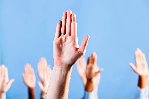 istock Man's hand makes "Stop!" gesture with many agreeing in background 168504664
