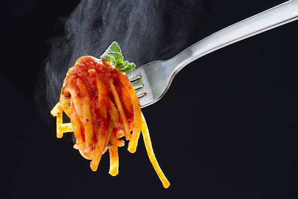 Steaming Pasta on a Fork A fork with hot pasta and marinara sauce. marinara stock pictures, royalty-free photos & images