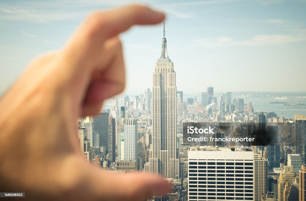 The Empire State building in hand - Funny photo Hand holding The Big Empire State building in NYC.  Building Exterior Stock Photo