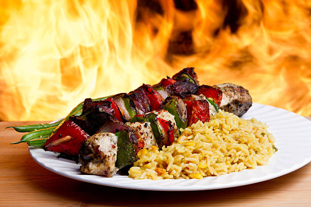 Grilled Chicken and beef Kebabs Delicious grilled chicken and beef kababson a plate with side dishes and flames in background fire pit photos stock pictures, royalty-free photos & images
