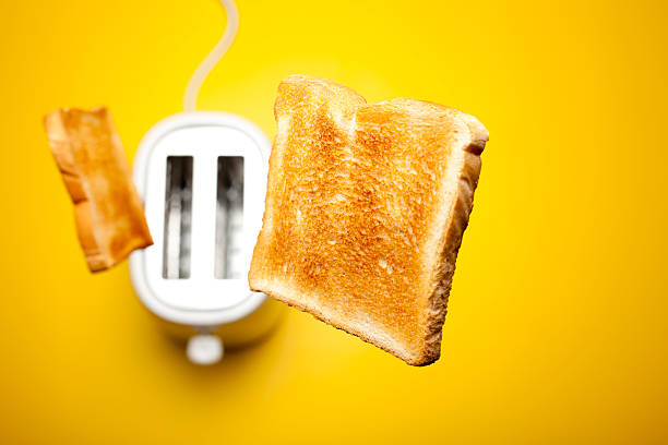 Jumping toast bread Photograph of fresh toast bread jumping out of the toaster. toaster stock pictures, royalty-free photos & images
