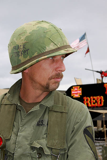 Vietnam Era Soldier. Vietnam Aircavalry soldier ,with stars and stripes behindhim.Re-enactor. special forces vietnam stock pictures, royalty-free photos & images