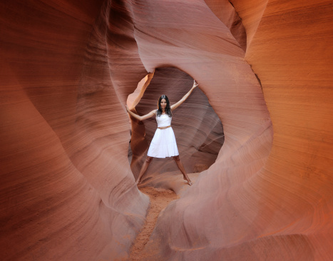 Beautiful woman standing in a hidden slot canyon. Nikon D3X + Tripod. Ambient Light.