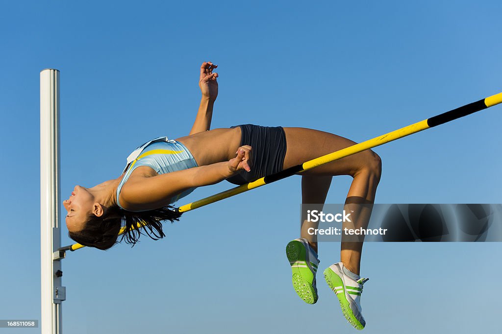 Belle jeune femme au saut en hauteur - Photo de Saut en hauteur libre de droits