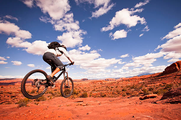 mountain biking in Utah biker getting some air on trails. slickrock trail stock pictures, royalty-free photos & images