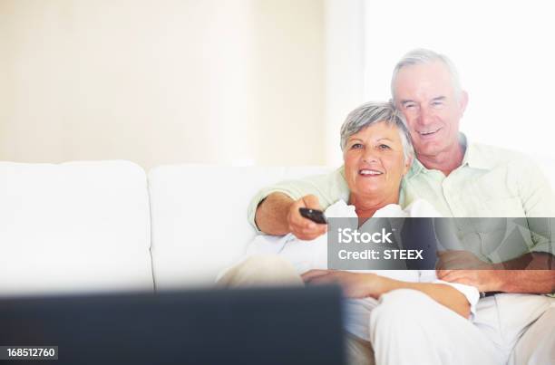 Tranquilo Pareja Viendo Televisión En La Sala De Estar Foto de stock y más banco de imágenes de Pareja mayor