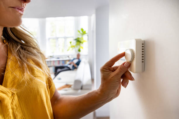 close-up on a woman adjusting the temperature with a dimmer - huisverwarming fotos stockfoto's en -beelden
