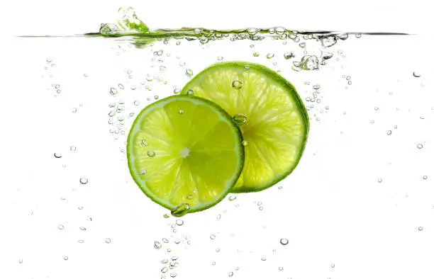 Photo of Lime slices splashing in fresh water