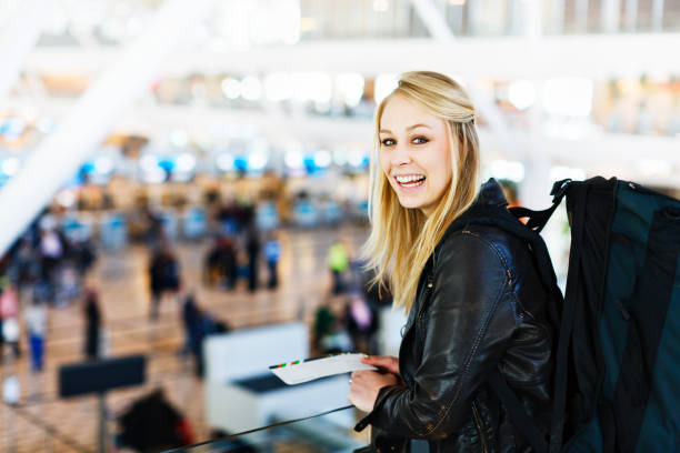istock Blonde backpacker with boarding pass smiles excitedly at airport check-in 168515971