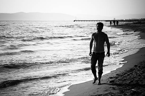 istock Man Silhouette walking on the beach 168516471