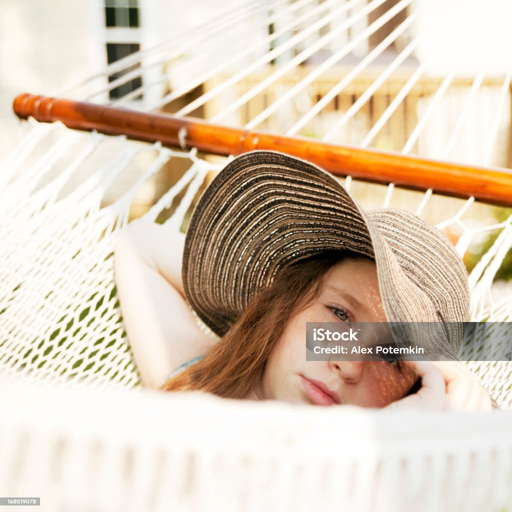 Adolescente com grande chapéu descansando na rede"" - Foto de stock de Cansado royalty-free