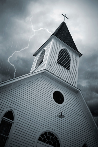 An old, rustic church, in the middle of a thunderstorm.