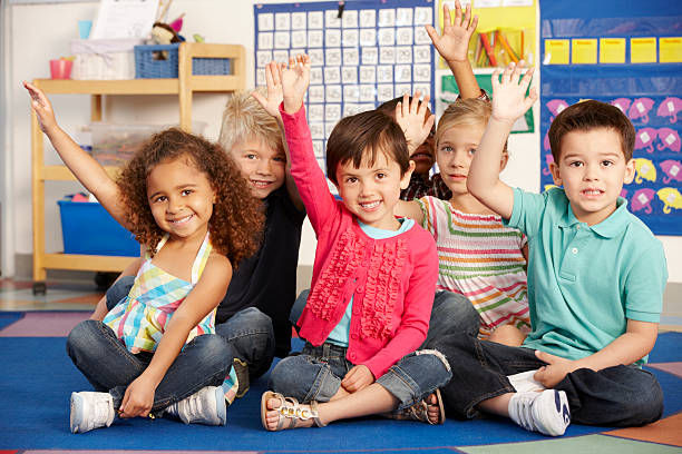 istock A group of elementary schoolchildren raising their hands 168521222
