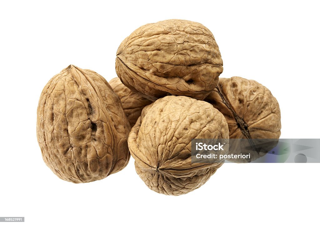 Close-up of five shelled walnuts over a white background Walnuts on White. Walnut Stock Photo