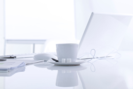 white clean office desk with laptop and coffee.