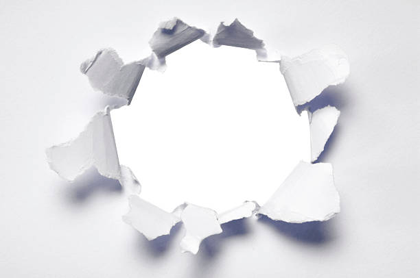 Ripped hole in blank paper A hole punched into white paper. punch stock pictures, royalty-free photos & images