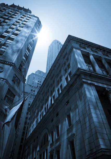 The tall buildings in the Wall Street area of Manhattan tend to be relatively close to each other giving a canyon-like feel. Sun bounces off the closely spaced building's windows creating an interesting dappled light effect.