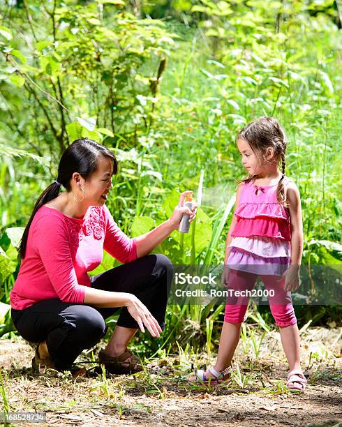 Madre Proteggendo La Figlia Con Bug Spray - Fotografie stock e altre immagini di Spray anti-insetti - Spray anti-insetti, Bambino, Puntura di zanzara