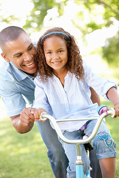 istock Father Teaching Daughter To Ride Bike 168529104