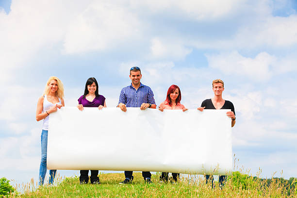istock young people holding a big poster 168531121