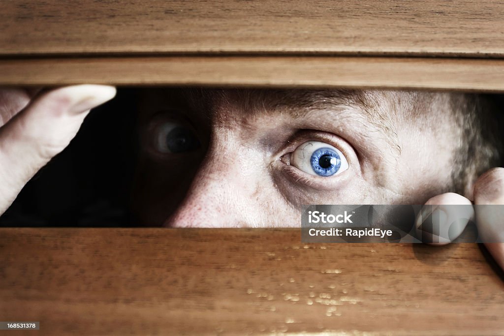 Large-eyed, homme apeuré potes au apprehensively stores en bois - Photo de Fantasmagorie libre de droits