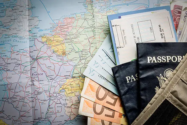 Photo of European Currency, American Passport, Airline Tickets and Map