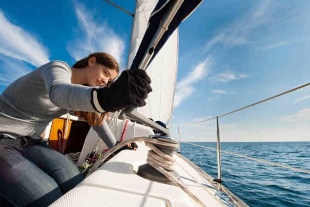 istock Sailing crew member on sailboat trimming front sail 168534100